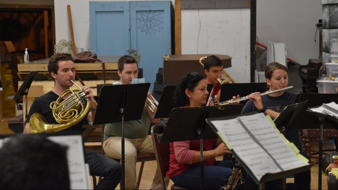 Orchestra members rehearse for a SPCT production
